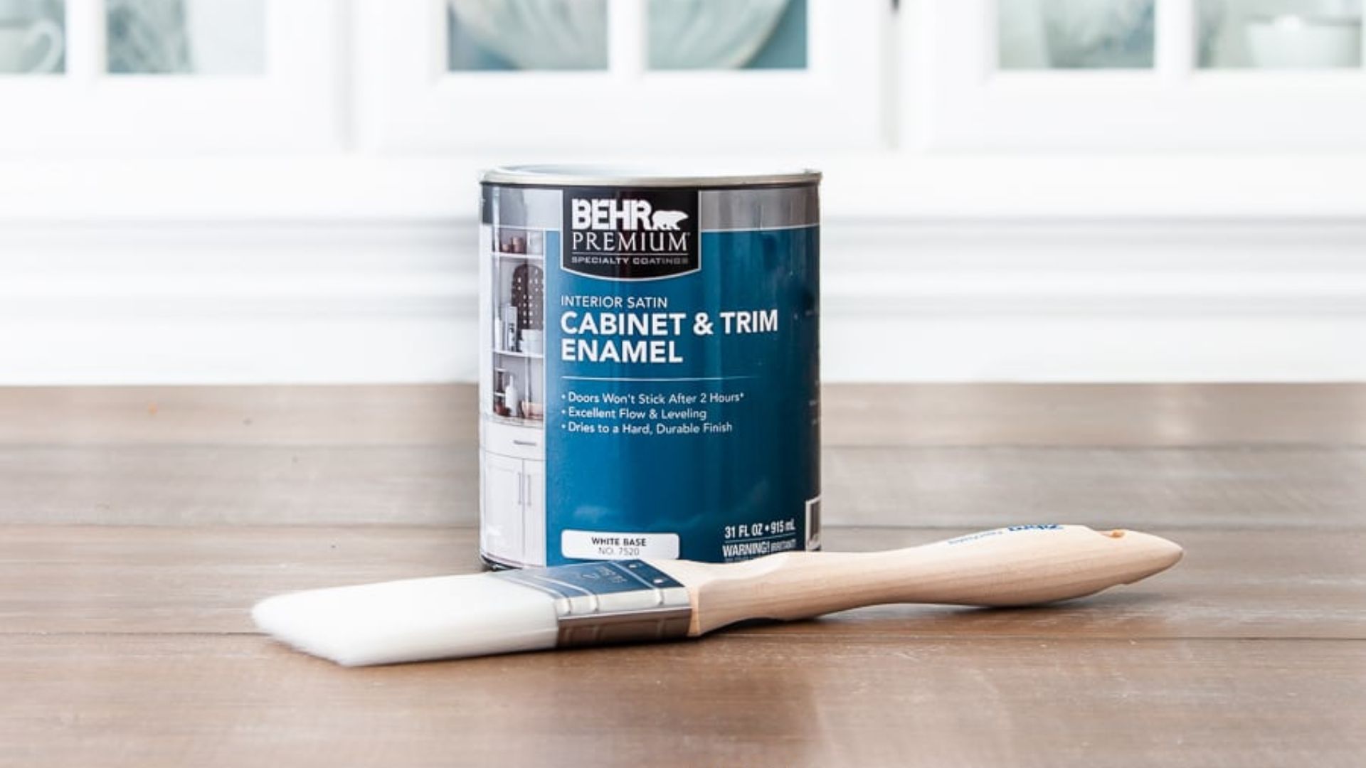 A can of paint and a paintbrush resting on a wooden table, ready for a creative project.