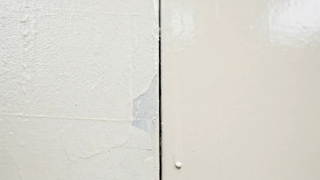 close up of painted surface showing difference between dry to touch outer layer and fully cured hardened paint underneath.