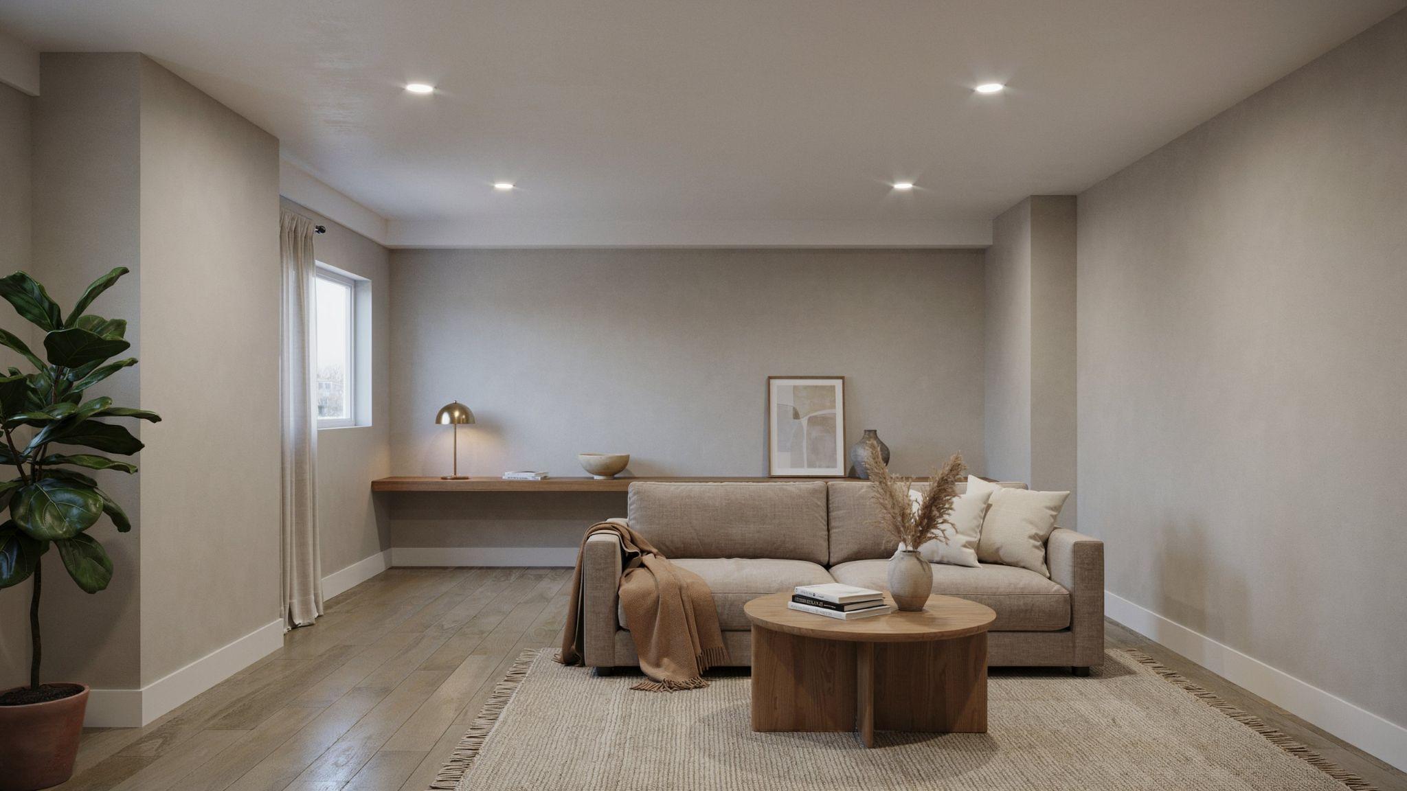 Cozy modern basement interior painted in warm greige tones influenced by Benjamin Moore Revere Pewter with classy neutral furnishings and soft lighting.