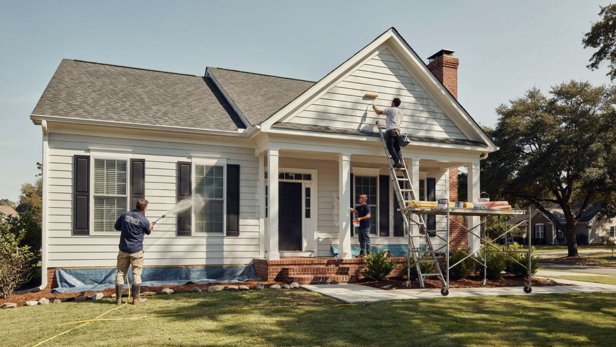 realistic house exterior painting process showing workers preparing surfaces, applying primer and paint coats, and completing cleanup during a full home painting project.