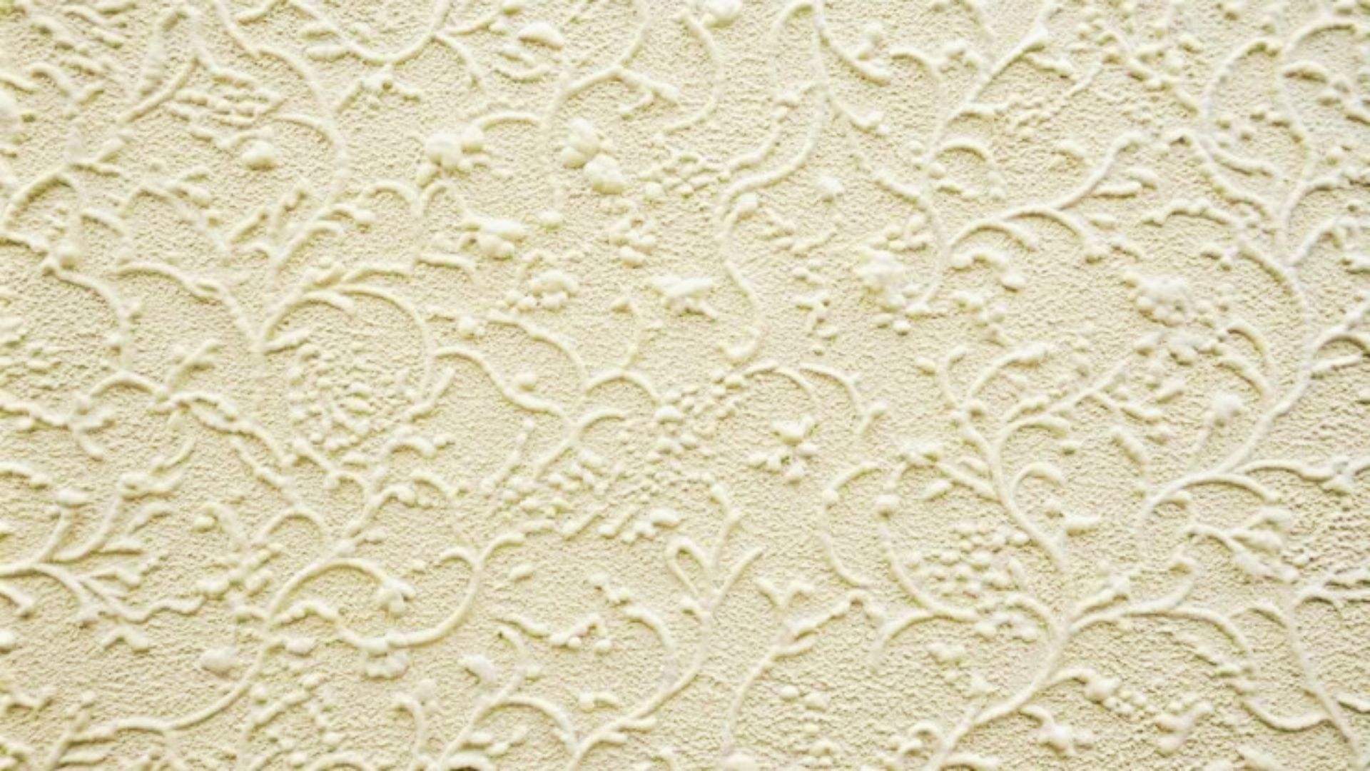 Lace or floral-pattern drywall texture in off-white with raised, vine-like details.