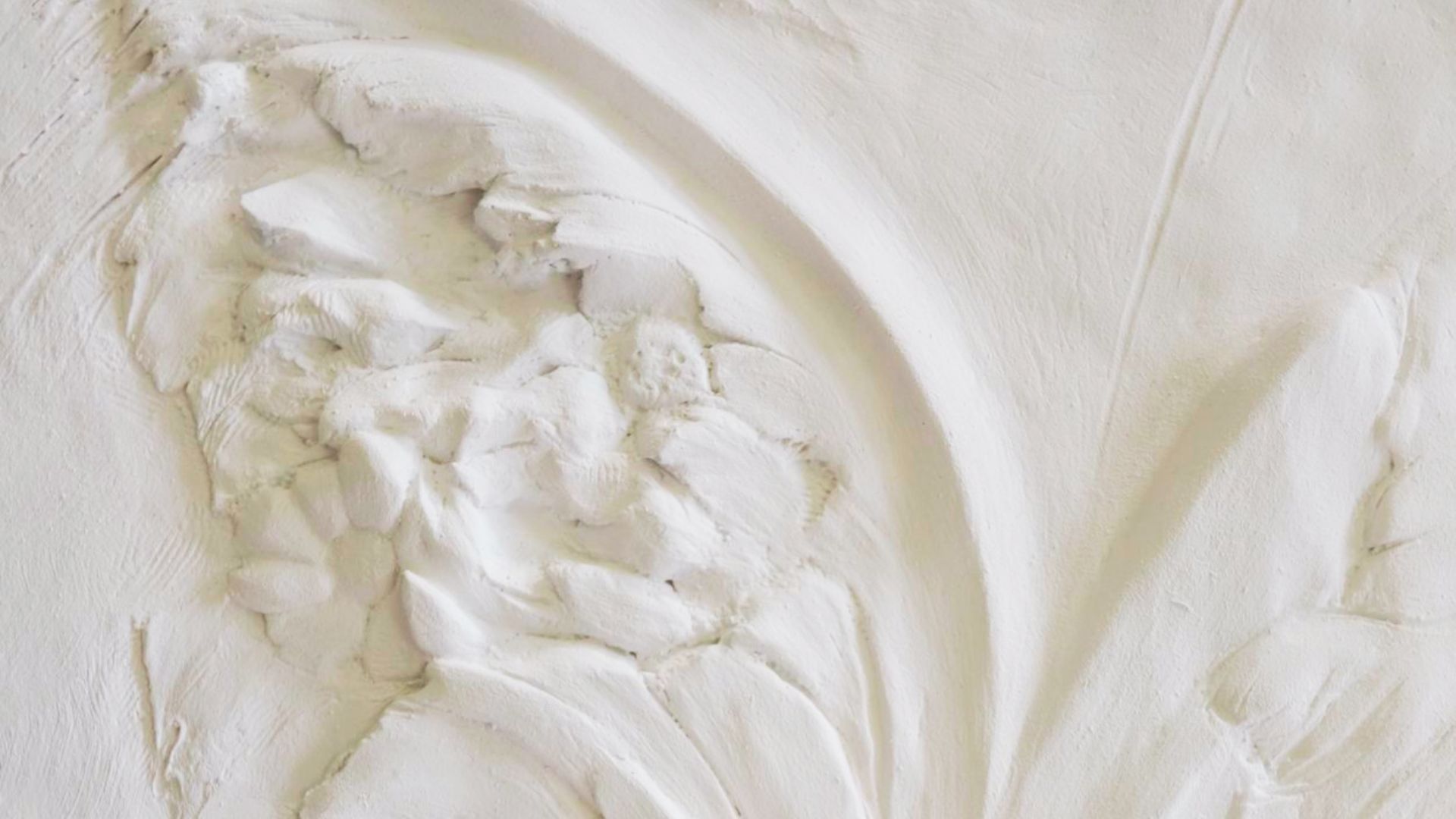 Heavy plaster drywall texture with thick, sculpted floral relief and bold brush strokes.