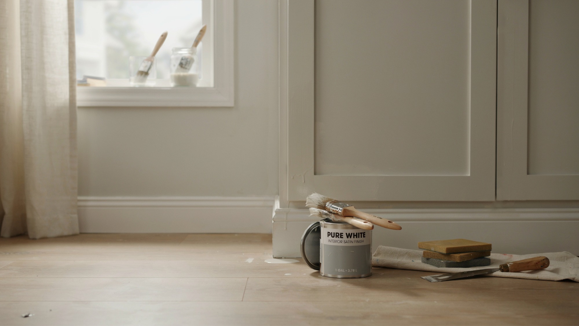 Freshly painted trim and cabinets drying in a clean, well-lit room with tools nearby.