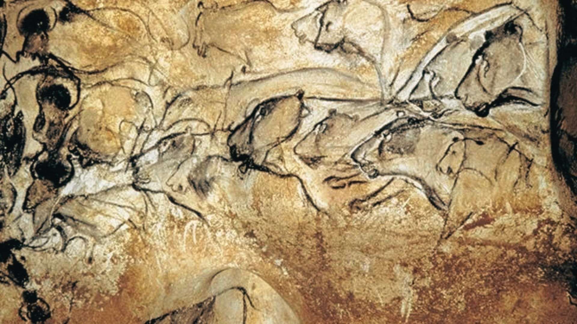 Prehistoric cave painting depicts horses and cattle in brown and black lines on stone.