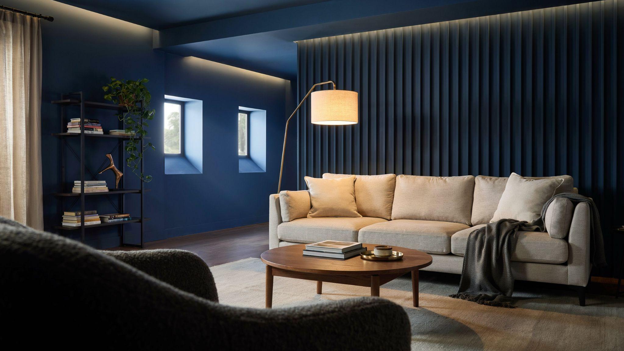 Classy modern basement interior featuring a deep navy accent wall influenced by Benjamin Moore Hale Navy with warm lighting and contrasting light furnishings.
