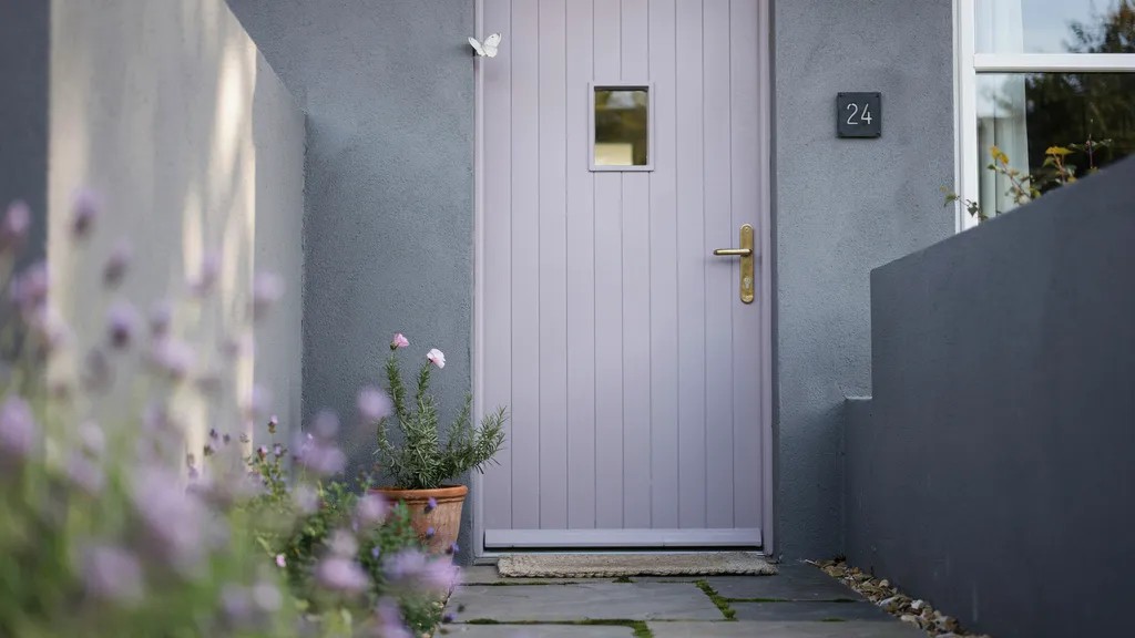 Lavender front door on gray exterior creating a soft yet standout entrance, adding gentle personality and calm visual appeal to the home.