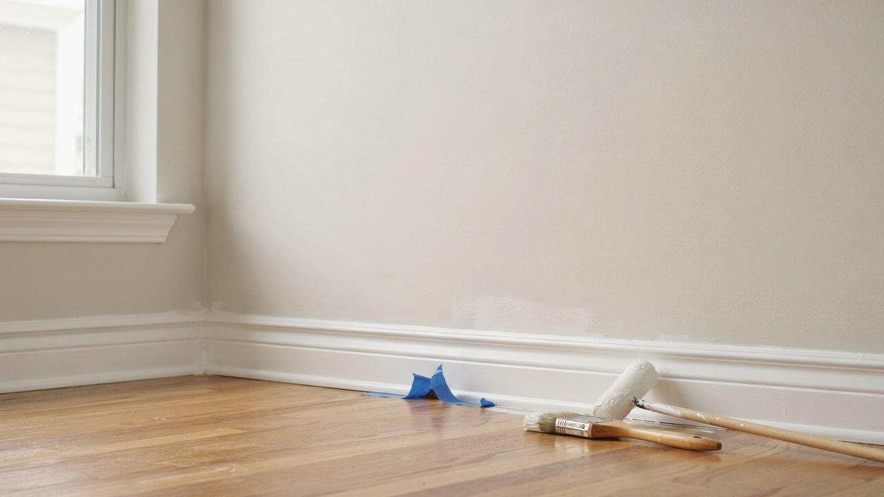 Close-up of baseboards with a smooth semi-gloss paint finish in a bright interior.